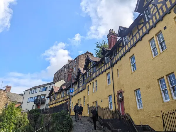 Edinburgh, İngiltere - 16 Temmuz 2025: Turistler Hawthornbank Lane 'in dik patikasında, geleneksel ahşap çerçeveli mimariye hayran kalarak yürüyorlar.