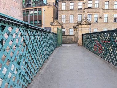 Edinburgh, İngiltere - 18 Temmuz 2025: Edinburgh Waverley İstasyonu 'nun tarihi bir köprüsü boyunca uzanan manzara, kendine özgü yeşil perçinlenmiş kafes örgüsü ve şehir mimarisini gözler önüne seriyor.