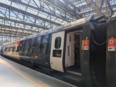 Glasgow, İngiltere - 12 Temmuz 2025: Glasgow Merkez İstasyonu 'nda açık kapısı olan bir Avanti Batı Yakası treni, etkileyici Viktorya döneminden kalma cam ve çelik çatının altında