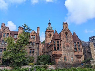 Edinburgh, İskoçya - 16 Temmuz 2025: Dean Village 'da restore edilmiş 19. yüzyıl binası olan tarihi Kuyu Mahkemesi, belirgin İskoç Baroniyer mimarisini açık mavi bir yaz gökyüzüne karşı sergiliyor