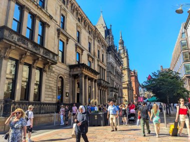 Glasgow, İngiltere - 12 Temmuz 2025: Yayaların oluşturduğu kalabalık Buchanan Caddesi boyunca, tarihi ve modern mimarisi açık mavi gökyüzü altında bulunan ünlü yayalar arasında yürüyor.