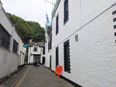 Glasgow, İngiltere - 13 Temmuz 2025: İnsanlar, Batı Yakası 'nda bulutlu bir gökyüzü altında canlı restoranları ve barlarıyla bilinen ünlü Ashton Yolu boyunca yürüyorlar.