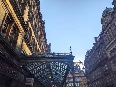 Glasgow, İskoçya, İngiltere - 13 Temmuz 2025: Açık bir akşam gökyüzü altında Glasgow Merkez tren istasyonunun ana girişinin tarihi Viktorya dönemi cephesine ve karmaşık demiryolu teçhizatına bakmak
