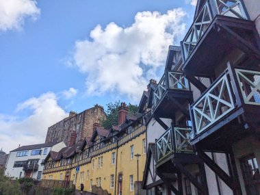 Edinburgh, İskoçya - 16 Temmuz 2025: Dean Village 'ın eşsiz kereste çerçeveli balkonları ve parlak bir yaz gökyüzüne karşı renkli cepheleriyle pitoresk ve tarihi mimarisinin bir görüntüsü