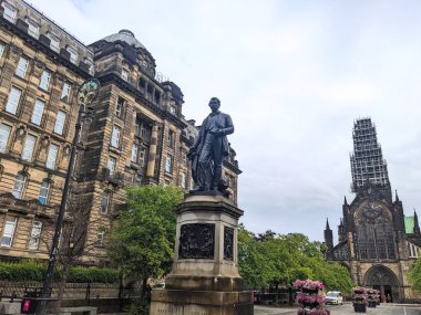 Glasgow, İskoçya - 14 Temmuz 2025: Tarihi David Livingstone heykeli Gotik Glasgow Katedrali 'nin restorasyonu ve yakınlardaki Kraliyet Reviri ile Katedral Meydanı' nda duruyor