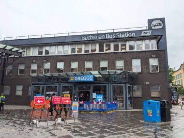 Glasgow, İngiltere - 15 Temmuz 2025: Merkezi bir ulaşım merkezi olan Buchanan Otobüs İstasyonu 'nun modern tuğla dış cephesi, yağmurlu bir günde yayaları ana girişten uzaklaştıran geçici işaretlerle