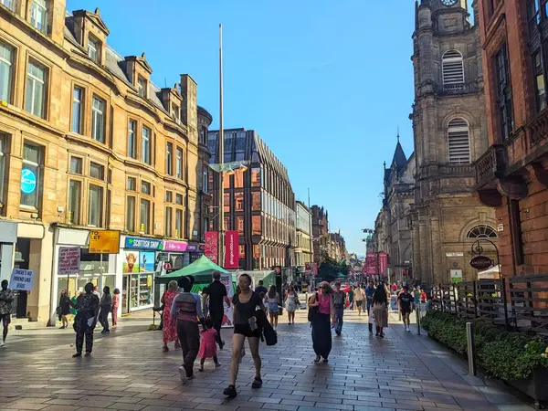 Glasgow, İskoçya, İngiltere - 12 Temmuz 2025: Tarihi ve modern mimarinin bir karışımı ile popüler bir alışveriş merkezi olan Buchanan Caddesi boyunca çeşitli yayalar geziyor