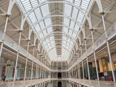 Edinburgh, İskoçya - 17 Temmuz 2025: İskoçya Ulusal Müzesi 'nin güneşli Büyük Galerisi, muhteşem Viktorya dönemi dökme demir mimarisi ve geniş kemerli cam avlusu sergilenmektedir.