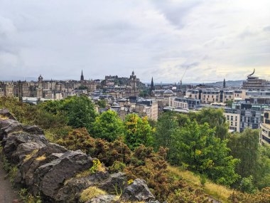 Edinburgh, İskoçya - 15 Temmuz 2025: Edinburgh Şatosu ve Eski Şehir mimarisi de dahil olmak üzere tarihi şehrin panoramik manzarası, Calton Hill 'in dramatik bulutlu gökyüzü altında
