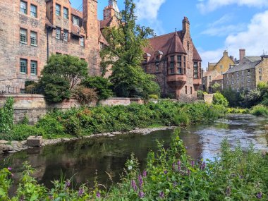 Edinburgh, İskoçya - 16 Temmuz 2025: Tarihi Kuyu Mahkemesi ve geleneksel taş binaların manzaralı manzarası, Leith 'in huzur dolu sularını şehrin gizli bir mücevheri olan Dean Village' da kaplıyor