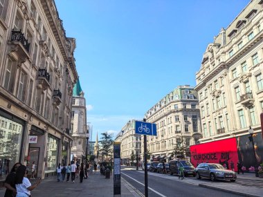 Londra, İngiltere - 09 Ağustos 2025: Müşteriler, muhteşem mimarisi, trafiği ve açık bir gökyüzü altında bisiklet sürdüğü Batı Yakası 'ndaki ünlü bir perakende satış noktası olan Regent Caddesi' nin kaldırımında yürüyorlar.