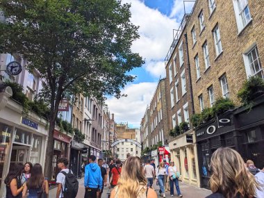 Londra, İngiltere - 09 Ağustos 2025: Soho 'da ünlü bir alışveriş merkezi olan Carnaby Caddesi' nde çeşitli yaya kalabalığı, modaya uygun butikler ve tarihi binalarla çevrili olarak geziniyor