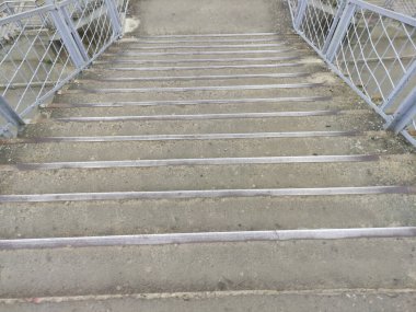 İstasyonda gri basamaklar, merdivenlerden inmeler, şehirde eski merdivenler.