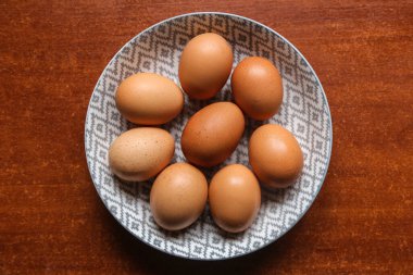 Yumurta içerikli yumurta, karanlık bir yüzeyde, bir tabakta, tahta bir masada.