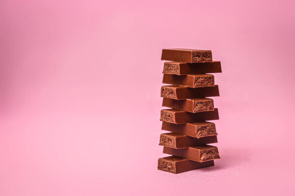 шоколадные кусочки на розовом фоне
