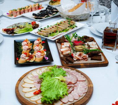 Kaynamış domuz eti, domuz eti dilimleri, siyah ekmek, bir şişe konyaklı otlar, açık büfe, nar, güzel bir masa örtüsü olan kiraz domatesleri..