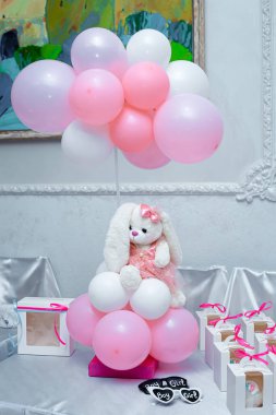 Pembe kalp şeklinde bir balon tutan yumuşak, pelüş bir tavşan.. 