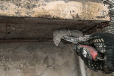 Duvar acil bir durumda ve onarılması gerekiyor. Tanrı 'nın yardımıyla, kadınların elleri duvarı kaplıyor..