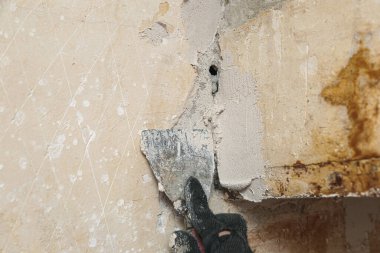 Duvar acil bir durumda ve onarılması gerekiyor. Tanrı 'nın yardımıyla, kadınların elleri duvarı kaplıyor..