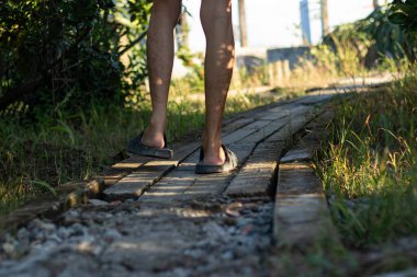 Kırsalda kırsal tuğla bir yolda yürüyen bir insanın bacakları ve ayakları. Bir yolculuğu, seyahati, keşfi ve ilerlemeyi temsil eden entellektüel ve kavramsal bir görüntü..