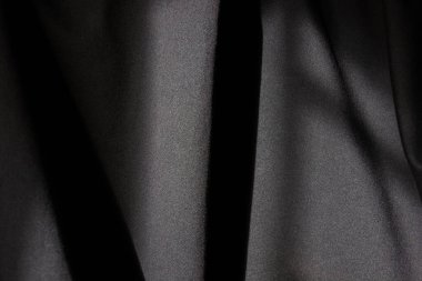 Siyah ipeğin dokusu ya da yumuşak, zarif kıvrımlı saten kumaş. Soyut, lüks ve zarif bir arka plan.