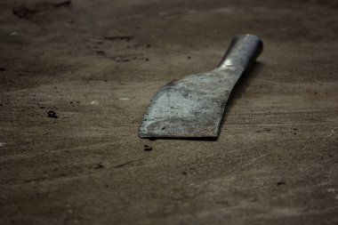 Eski, yıpranmış bahçe bıçağı sert beton zeminde terk edilmiş. İş gücü kavramı, unutulmuş şeyler, ve kırsal
