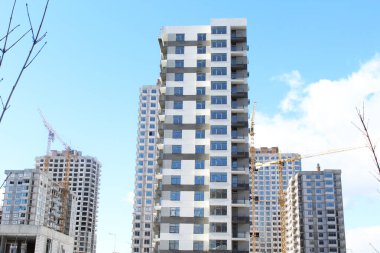Mavi gökyüzüne karşı apartman inşaatı. Vinçli inşaat alanı. Şehirdeki büyük bina.