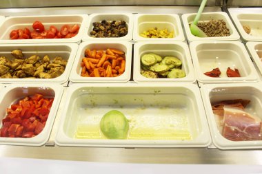 Sağlıklı yemek. Salatalar için malzemeler kapanıyor. Sebze, peynir, sebze, yumurta, havuç, salatalık restoranın vitrininde. sağlıklı yiyecekler