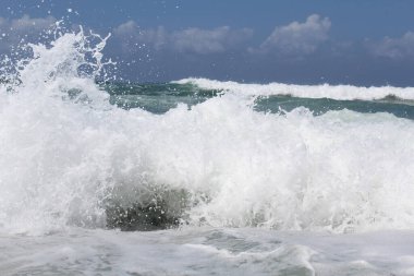 Doğal arkaplan, mavi gökyüzü arka planında izole edilmiş beyaz su dalgaları sıçratır