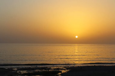 Sahilin ortasında, denizin ortasında güzel bir gün batımı..