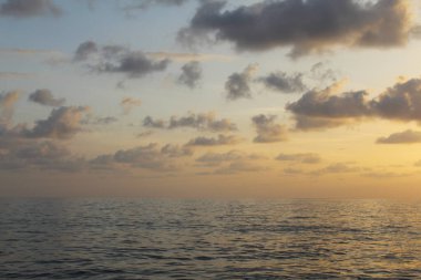 Gün batımında okyanusta bir tekne.