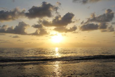 Bulutlu gökyüzünün doğal arkaplanı ve deniz üzerinde gün batımı
