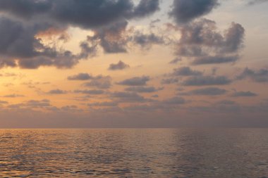 Gün batımında okyanusta bir tekne.