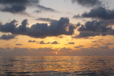 Bulutlu gökyüzünün doğal arkaplanı ve deniz üzerinde gün batımı