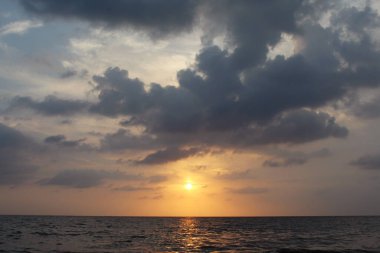 Gün batımında denizin üzerinde bulutlu gökyüzünün doğal arkaplanı