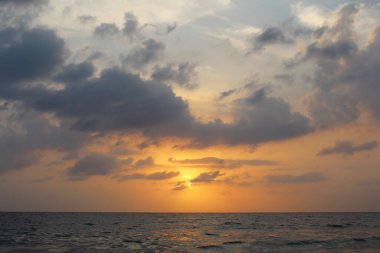 Sahilde gün batımı Denizle