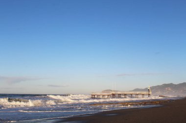 Dalgalar sahilin iskelesine çarpıyor.