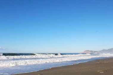 Dalgalar ve mavi gökyüzü ile güzel deniz plajı