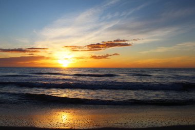 Sahilde gün batımı, doğal arka plan Denizin üzerinde güzel bir gün doğumu,