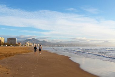 Denizin kıyısındaki kumsalda yaşayan insanlar.