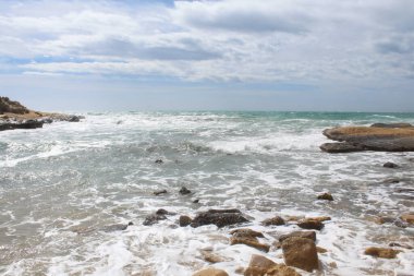 Deniz ve taşların doğal arka planı, İspanya 'daki Akdeniz kıyılarının güzel manzarası, denizde dalgalar.