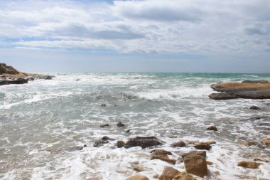 Deniz ve taşların doğal arka planı, İspanya 'daki Akdeniz kıyılarının güzel manzarası, denizde dalgalar.