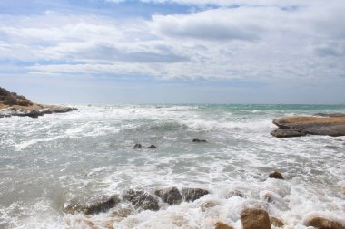 Deniz ve taşların doğal arka planı, İspanya 'daki Akdeniz kıyılarının güzel manzarası, denizde dalgalar.