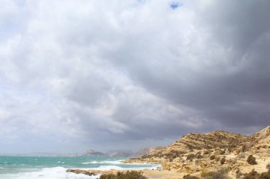 Deniz ve kayaların üzerindeki bulutlu gökyüzü, bulutlu bir günde deniz ve kayaların manzarası, Akdeniz İspanya