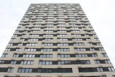 Balkonları ve pencereleri olan yeni bir apartman.