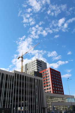 Ukrayna 'nın başkenti Kyiv' de bir vinç inşaatı, şehirde yeni binalar ve mavi gökyüzü.