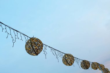 Dekoratif noel baloları mavi gökyüzünün arka planında bir Noel ağacında asılı duruyor. Yılbaşı geçmişi. Noel süslemeleri.