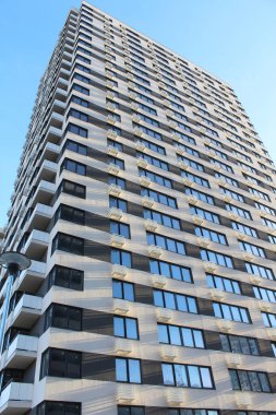 Modern bina, gökdelen mavi gökyüzü arka planında izole edilmiş, modern apartman yakın plan 