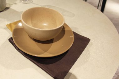 Bir tabak çorba, bir tabak mendil ve bir masa.