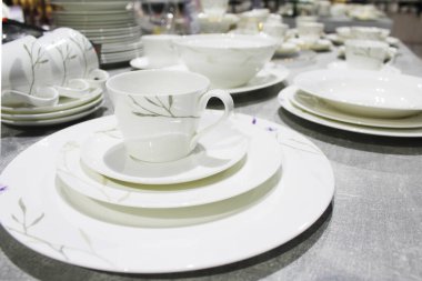 Beyaz arka planda kaşıkla beyaz porselen plakaların yakın plan çekimi.